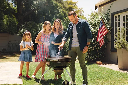 family outside cooking on grill